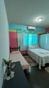 2 letti in una camera con parete colorata di Aráras Suites a Palmas