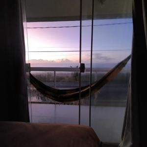 una hamaca en una habitación con vista al mar en Pousada dos Sonhos Costa Azul, en Rio das Ostras