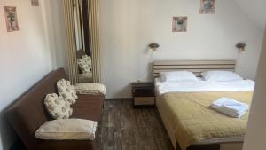 een slaapkamer met twee bedden en een stoel erin bij Cetățuia - Ultra-Central Râșnov Stay - Parking and Nature Close to Bran, Dino Parc and More in Rîşnov