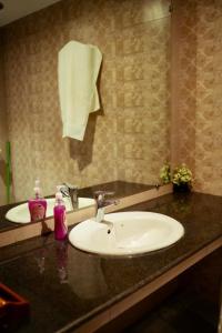 a bathroom counter with a sink and a mirror at Luxury cozy studio apartment with balcony in Lahore