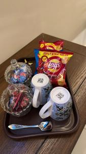 a tray with cups and snacks on a table at Luxury cozy studio apartment with balcony in Lahore