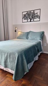 um quarto com uma cama com um cobertor verde em Ipiranga Flat - Guarapari, Espírito Santo em Guarapari