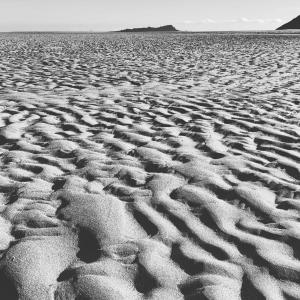 a black and white photo of a sandy beach at LAIDA BEACH by Urdaibai Experience in Ibarrangelu