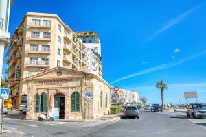an old stone building on the side of a city street at Stunning Seafront Apartment with Panoramic Views in Sliema