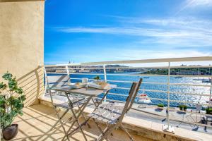 a table and chairs on a balcony with a view of the water at Stunning Seafront Apartment with Panoramic Views in Sliema