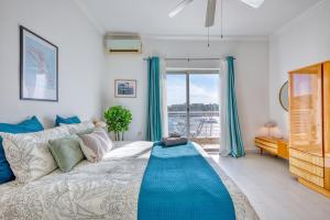 a bedroom with a bed with a blue blanket on it at Stunning Seafront Apartment with Panoramic Views in Sliema