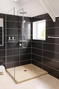 a bathroom with a shower with black tiles at Villa Lawrencia in Morne-à-lʼEau +10 photos