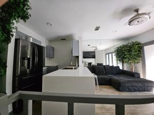 a kitchen and a living room with a couch and a counter at Urban Treehouse in Dallas