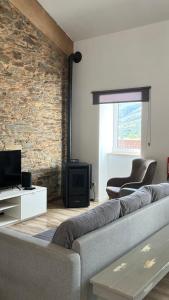 VerdelhosLugar da Borralheira的带沙发和砖墙的客厅