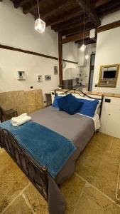 a bedroom with a large bed with blue pillows at La perla casa vacanze in Barletta