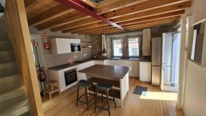 a kitchen with a counter and stools in it at Moradia Sisudo in Colares