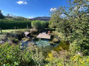 PeratschitzenVerwandlerei Berg&See的池塘里有一张木桌和长凳