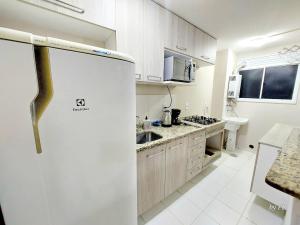 une cuisine blanche avec un réfrigérateur dans une pièce dans l'établissement Graciosa Reserva Ipanema, à Porto Alegre 29 autres photos