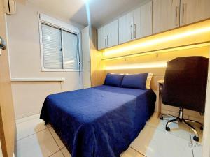 Cette petite chambre comprend un lit bleu et un bureau. dans l'établissement Graciosa Reserva Ipanema, à Porto Alegre