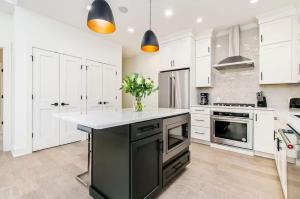 a kitchen with white cabinets and a black island at Short North Convention Garage Parking! in Columbus