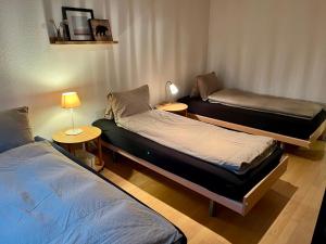a room with two beds and a lamp in it at Grosse Ferienwohnung ideal für Gruppen, nähe Thun und Interlaken in Steffisburg +54 photos