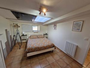 a bedroom with a bed and a ceiling fan at Gîte Kerlosvézan, à la campagne, proche mer in Lampaul-Ploudalmézeau