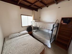 a room with two bunk beds and a window at Casa de Playa Alarcon - Huacura in Bocapán
