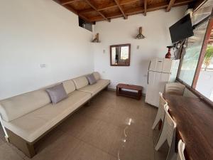 a living room with a couch and a refrigerator at Casa de Playa Alarcon - Huacura in Bocapán
