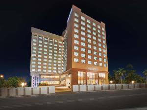 a large hotel building with a night at Novotel Mumbai International Airport in Mumbai