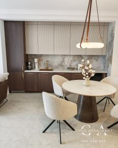 une cuisine avec une table et des chaises dans une pièce dans l'établissement Gold Apartment E47 Studio Let's Sea Baltic Park Gąski, à Gąski