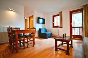 a living room with a table and a couch at Escapada de esquí I Cerca de Grandvalira con Parking in Soldeu