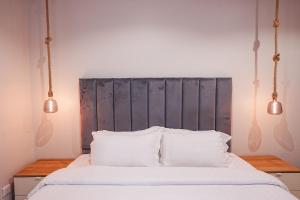 ein Schlafzimmer mit einem Bett mit zwei Kissen und zwei Lichtern in der Unterkunft Mabaat-White Pearl Compound 600 C Villa 26 in Dschidda + 15 Fotos