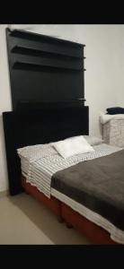 a bed with a black headboard in a room at Casa Zoe - Habitación Económica en Casa Familiar in Guayabal