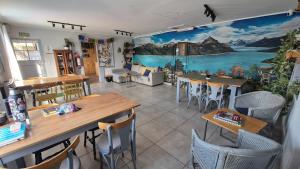 a restaurant with tables and chairs and a mural on the wall at Lago Argentino Hostel in El Calafate