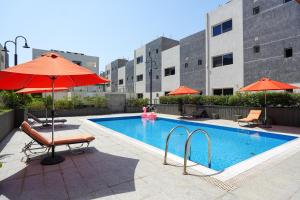a swimming pool with umbrellas and chairs and a pool at Mabaat-White Pearl Compound 600 C Villa 24 in Jeddah
