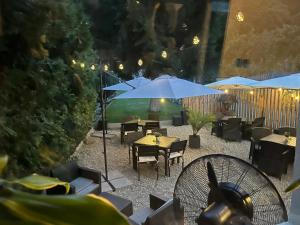 a patio with tables and chairs and umbrellas at Cetățuia - Ultra Central Râșnov Stay & Parking free in Râşnov +55 photos