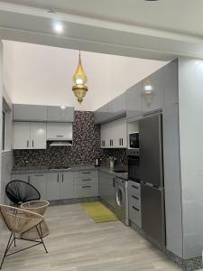 a kitchen with white cabinets and a washer and dryer at KSyiimmo Signature aéroport Marrakech in Marrakesh