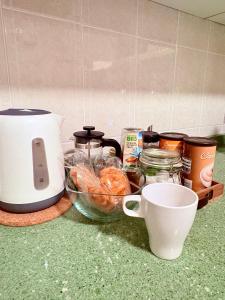 a counter with a counter top with food and a toaster at Acogedora habitación en barrio madrileño con encanto in Madrid