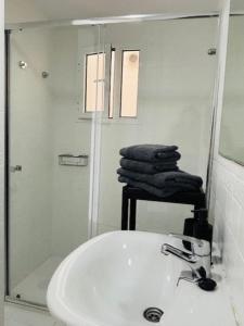 a white bathroom with a sink and a mirror at First-Line Las Canteras Beach in Las Palmas de Gran Canaria +23 photos