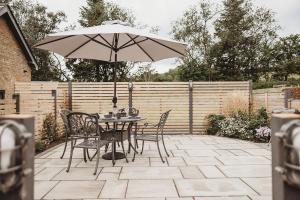 a table and chairs with an umbrella on a patio at Ty Bach in Llanwrtyd Wells