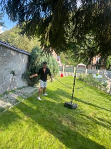 a man is standing in a yard with a pole at Cetățuia - Ultra Central Râșnov Stay & Parking free in Râşnov
