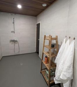 a bathroom with a shower and a shelf with towels at Teddy's Hideout in Rovaniemi