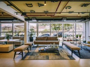 ポソス・デ・カルダスにあるibis Styles Poços de Caldasのソファと椅子とテーブルのあるリビングルーム