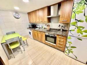 una cocina con armarios de madera y una mesa con una silla amarilla en El Pixueto Amarillo, en Cudillero