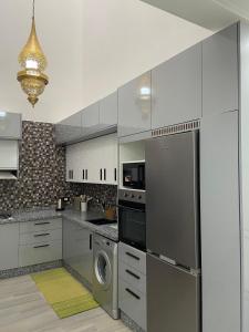 a kitchen with stainless steel appliances and a washer and dryer at KSyiimmo Signature aéroport Marrakech in Marrakesh +12 photos