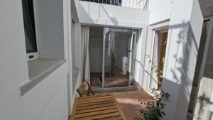 a small house with a glass door on a balcony at Moradia Sisudo in Colares