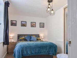 a bedroom with a bed with a blue blanket at Ladybower Apartment Central Glossop in Glossop