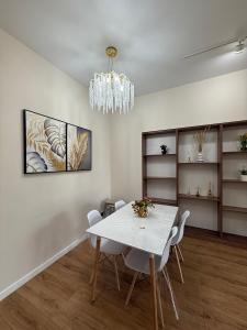 a dining room with a white table and chairs at С Видом на Горы Квартира возле ТРЦ Mega Center in Zhezdi