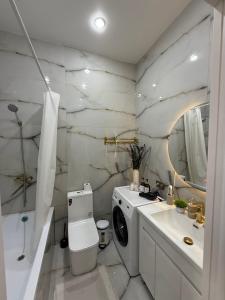 a bathroom with a washing machine and a sink at С Видом на Горы Квартира возле ТРЦ Mega Center in Zhezdi +9 photos