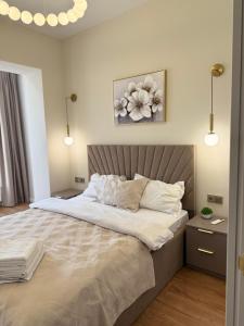 a bedroom with a large bed with white sheets at С Видом на Горы Квартира возле ТРЦ Mega Center in Zhezdi