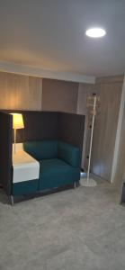 Habitación con sofá verde y lámpara en Rué de Rome, en Lucé