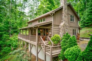 a cabin in the woods with a wrap around porch at Kaylee's Kabin in Vilas