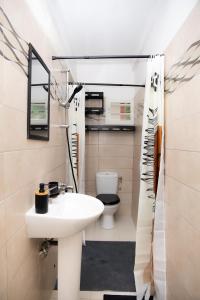 a bathroom with a sink and a toilet at Gosier séjour in Le Gosier