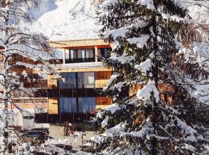 a building in front of a snow covered mountain at Chillas Appartements Urlaub mit Mehrwert inklusive SILVRETTA CARD PREMIUM in Kappl