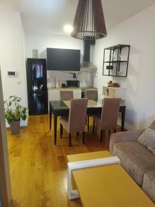 a living room with a table and a kitchen at Apartman Markovic Rich in Loznica +10 photos